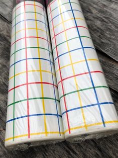 two rolls of wrapping paper sitting on top of a wooden table next to each other