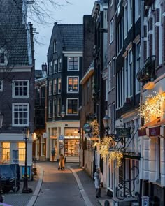 a narrow street lined with tall buildings at dusk