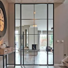 a large clock mounted to the side of a wall in a living room next to a doorway