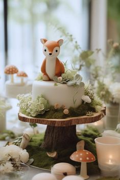 there is a cake with a fox on it and moss growing around the base, as well as mushrooms