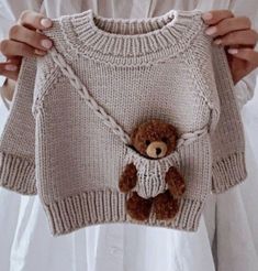 a teddy bear is attached to a sweater