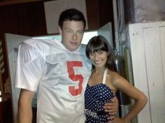 a man and woman standing next to each other in front of a refrigerator with the number 5 on it