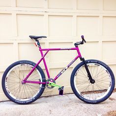 a purple bike parked in front of a garage door