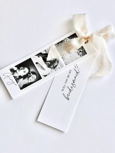 two white cards with black and white photos on them, tied together by a ribbon