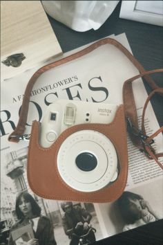 a brown camera bag sitting on top of a magazine