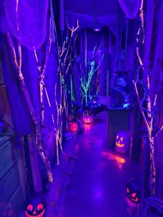 halloween decorations are lit up in purple and blue lights at the entrance to a house