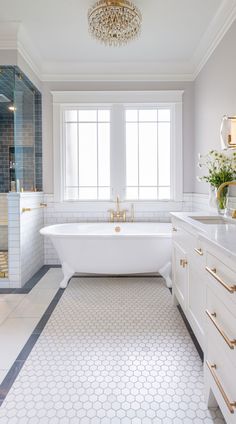 a bathroom with a large white tub next to a walk in shower and two sinks