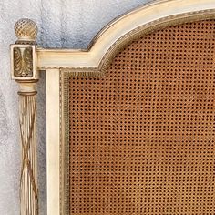 a close up of an old fashioned headboard with wicker and gold trimmings