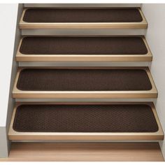 a set of stairs with brown carpet on the bottom and bottom steps, in front of a white wall