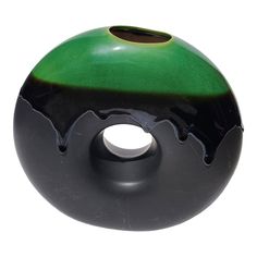 a black and green vase sitting on top of a white table