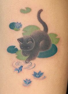 a tattoo with a black cat on it's thigh and blue flowers in the background