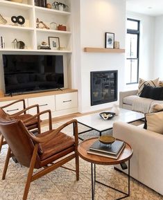 a living room filled with furniture and a flat screen tv mounted on a wall above a fire place