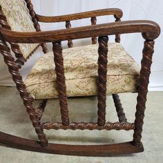 a wooden rocking chair sitting on top of a carpeted floor