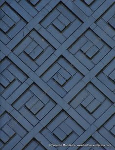 a bird is perched on the side of a blue wall with squares and rectangles