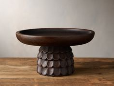 a wooden bowl sitting on top of a wooden table