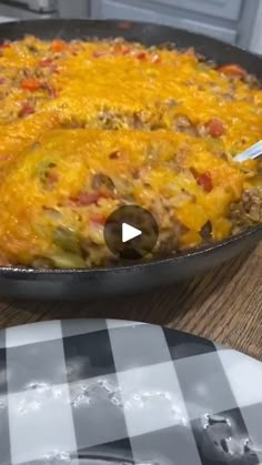 a skillet filled with food sitting on top of a wooden table