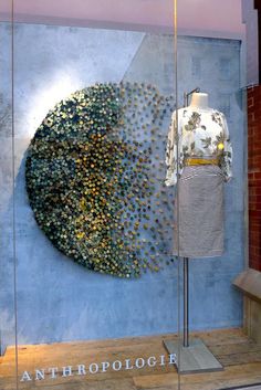 a dress on display in front of a blue wall with an anthropoloic design