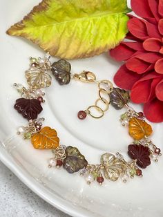 This gorgeously unique bracelet features beautifully detailed Czech glass leaves in crisp autumn hues. Rich colors of olive green, golden crystal, warm pumpkin orange, and deep berry burgundy wrapped in 14k yellow gold filled dance along this extraordinary piece. Petite clusters of peridot, garnet, peach freshwater pearls and rainbow Austrian Crystal are nestled between each tender leaf. Finished with a generously-sized 14k yellow gold filled lobster claw clasp and polished, oval link extender c Acrylic Nails Almond Shape, Golden Crystal, Cluster Bracelet, Pumpkin Bead, Crisp Autumn, Cluster Bracelets, Beaded Leaf, Rose Quartz Earrings, Almond Shape