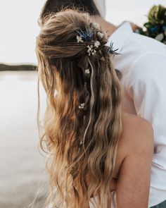 the back of a woman's head with flowers in her hair