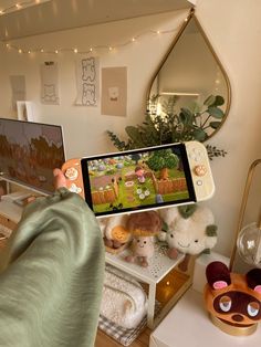 a person holding up a cell phone to take a picture of stuffed animals on the table