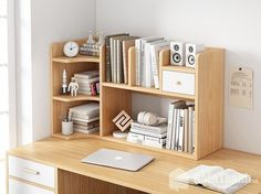 an apple computer sitting on top of a wooden desk next to a bookshelf