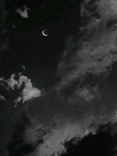 black and white photograph of the night sky with clouds, moon and stars in it