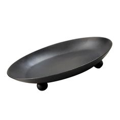 a black plate sitting on top of a white surface with wheels in front of it