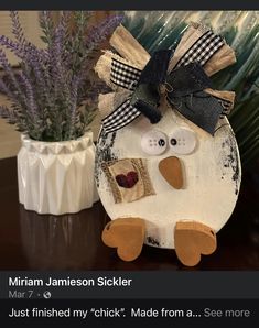 a white bird with a black bow on it's head sitting next to some lavenders