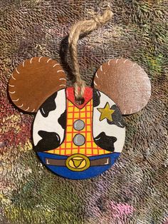 a mickey mouse ornament hanging from a rope on a carpeted area with other decorations