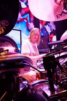 a man sitting in front of a drum set