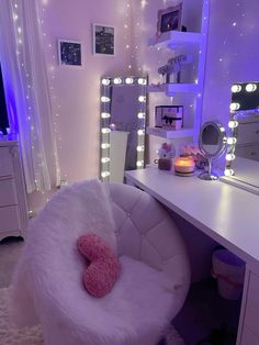 a white chair sitting in front of a desk with a mirror and lights on it