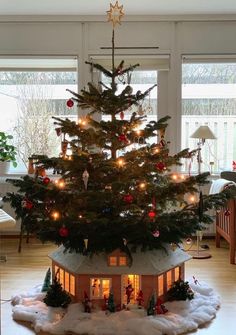 a small christmas tree in the middle of a house with lights on it's roof