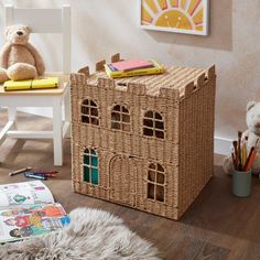 a wicker doll house sitting on top of a wooden floor next to a teddy bear