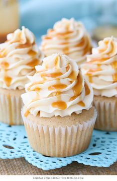 cupcakes with frosting and caramel on a blue doily