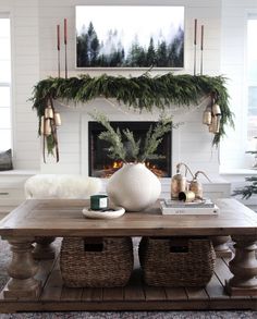 a living room decorated for christmas with wreaths on the mantel and coffee table