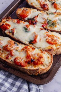 four slices of bread topped with cheese and tomatoes