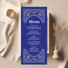 a blue menu card sitting on top of a table next to a vase with flowers