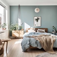 a bedroom with blue walls and wooden floors