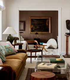 a living room filled with furniture and a painting on the wall