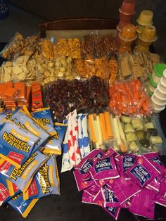 a variety of snacks are laid out on a table top, including candy bars and candies