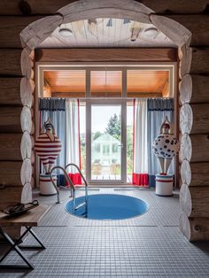 an indoor swimming pool in the middle of a room with wooden walls and flooring