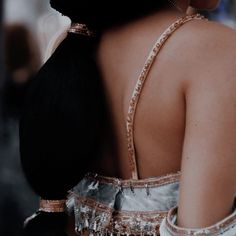 the back of a woman's dress with beads on it