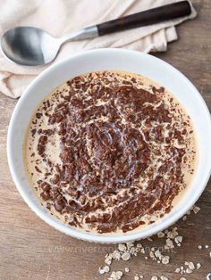 a bowl filled with chocolate and oatmeal on top of a wooden table