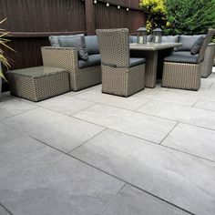 an outdoor patio with wicker furniture and potted plants