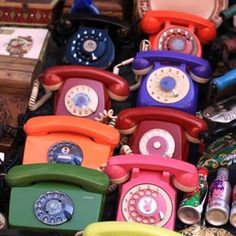 many different colored telephones sitting on top of each other