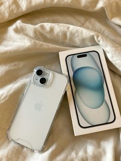 an iphone case sitting on top of a bed next to a box with the phone in it