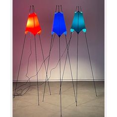 three different colored lamps sitting on top of a floor