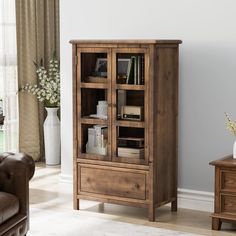 a wooden cabinet with glass doors in a living room