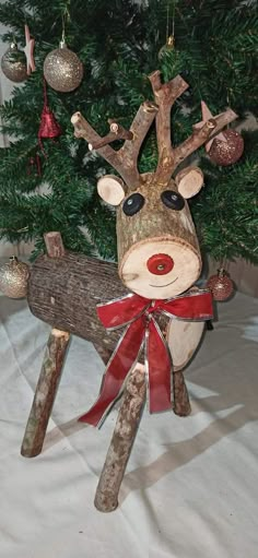 a wooden reindeer ornament hanging from a christmas tree with ornaments on it's head