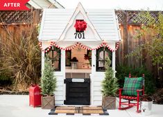 a small white house decorated for christmas with decorations on the roof and front door, sitting outside